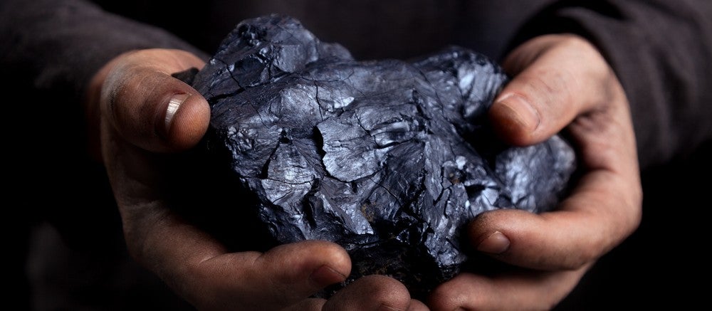 A person holding a lump of coal.