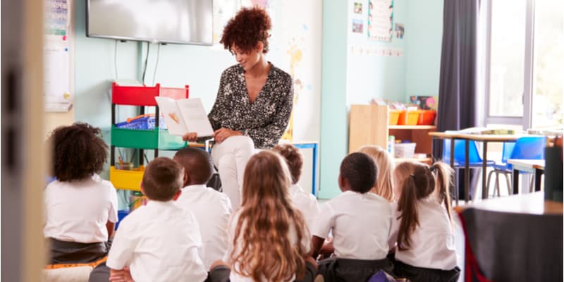 A teacher reading a story to a group of elementary students.