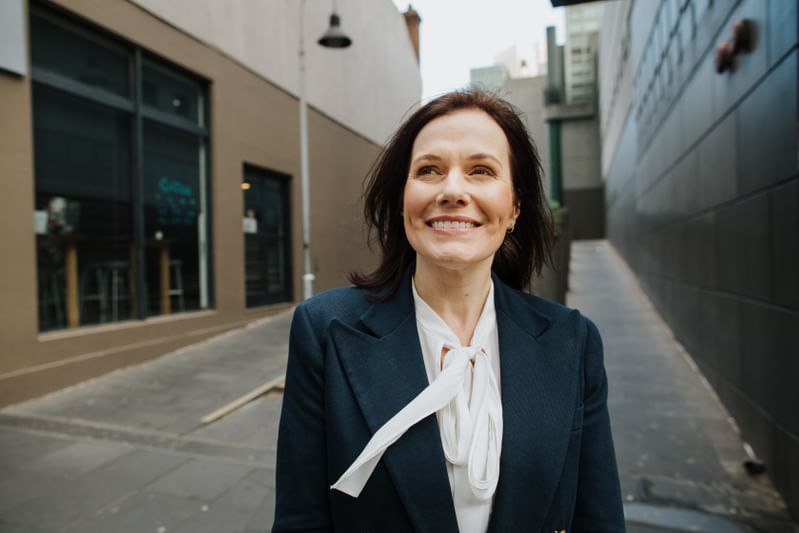 Female academic smiling as she walks down the street