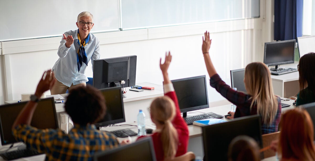 Teacher smiling at students all engaging in conversation