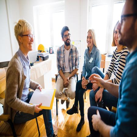 A diverse group of individuals engaged in conversation while seated around a table, fostering collaboration and connection.