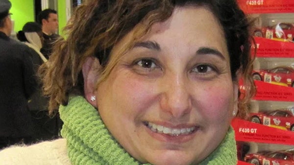 A woman in a white sweater complemented by a green scarf, showcasing a fashionable and cozy appearance.