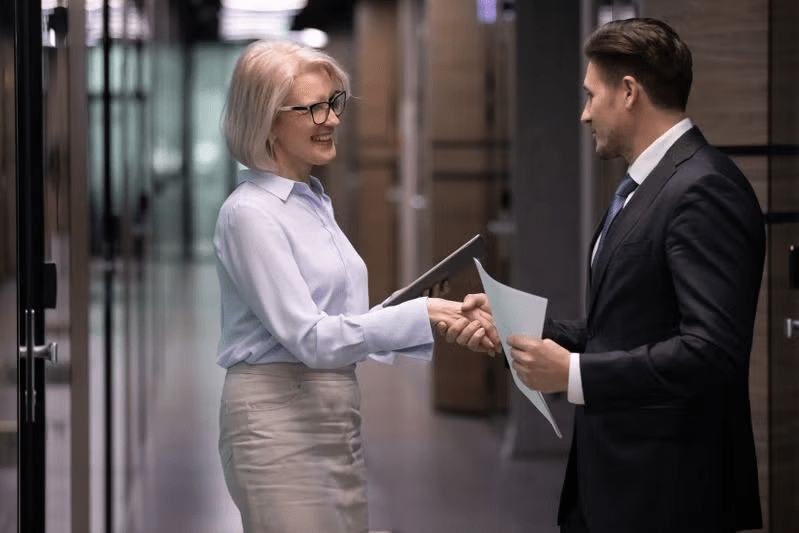 Employer shaking hands with an MBA graduate.