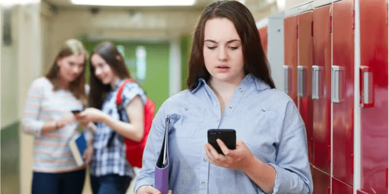 Female High School Student Bullied By Text Message In Corridor