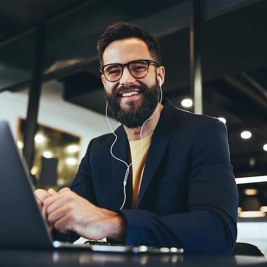 Male Business student on a laptop smiling at camera