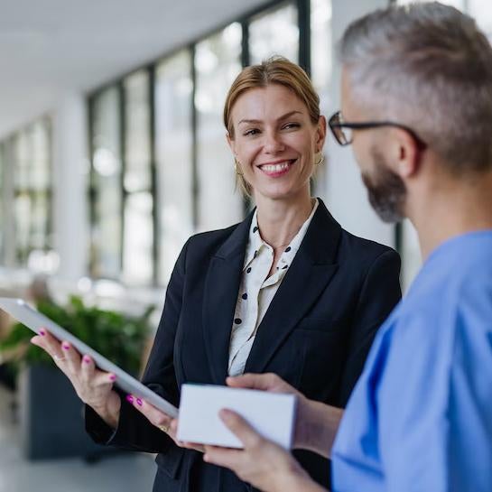 Female business student in a suit talking to a man in scrubs