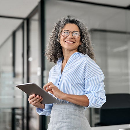A female MBA student in a modern office environment smiling