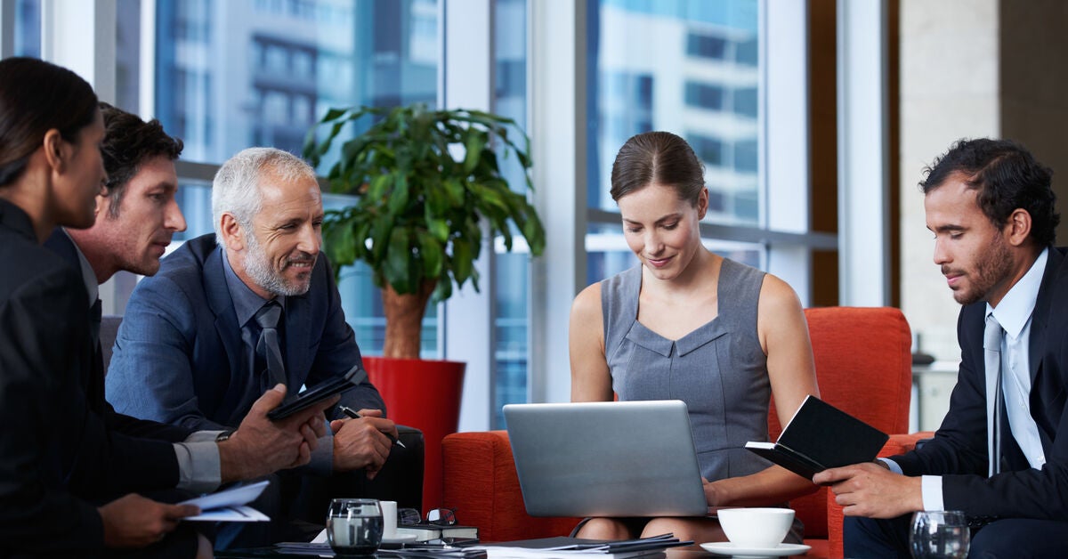 Corporate lawyers sitting around a table discussing work