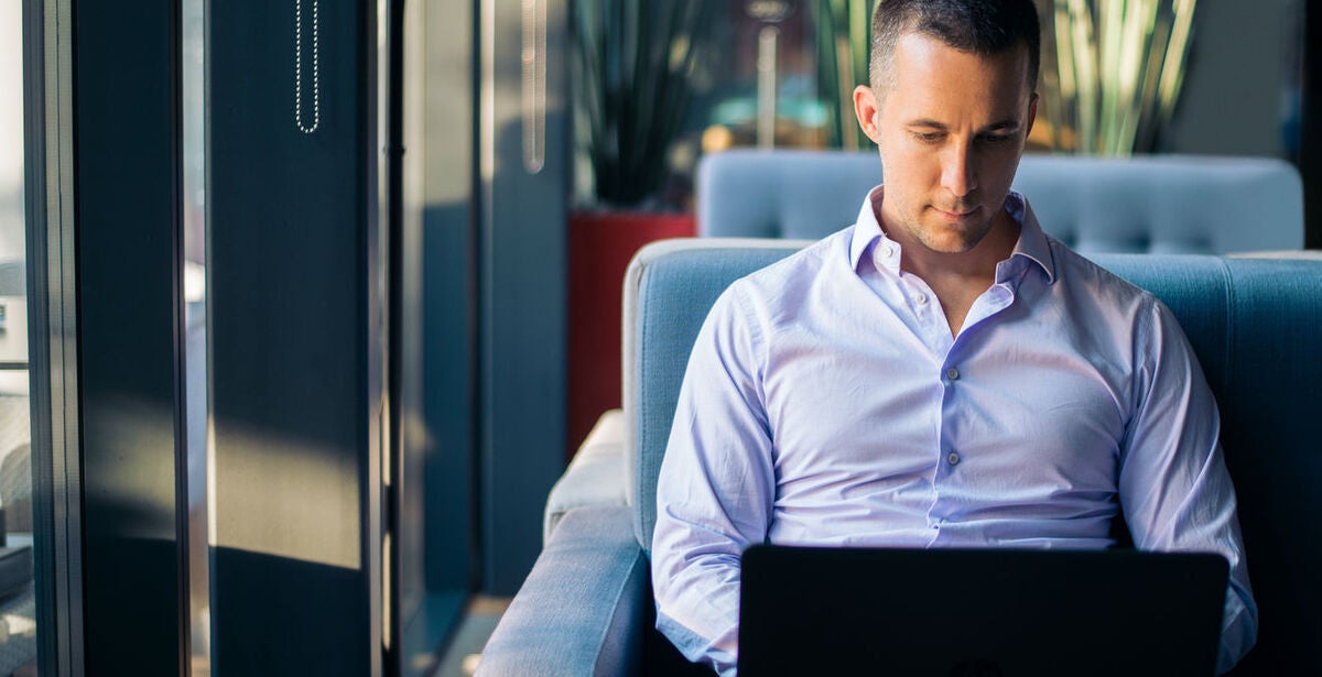 Man sitting on couch with laptop open