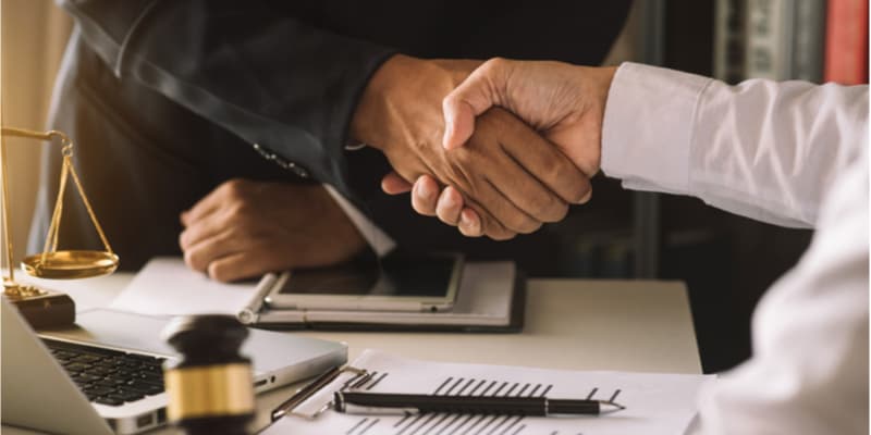 business people and lawyers discussing contract papers sitting at the table