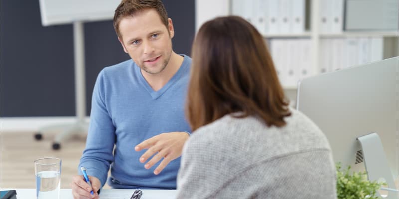 A male teacher having a meeting with a parent about a student's progress.