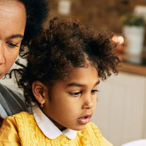 A woman and a child collaboratively working on a laptop, engaged in a productive learning experience together.