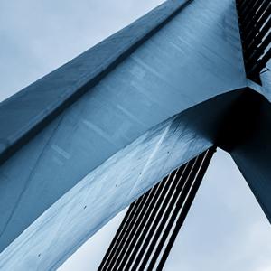 A close-up view of a bridge against a clear blue sky, showcasing its structure and the vibrant atmosphere.