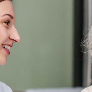 A doctor and patient engaged in a conversation at a desk, discussing health matters in a professional setting.