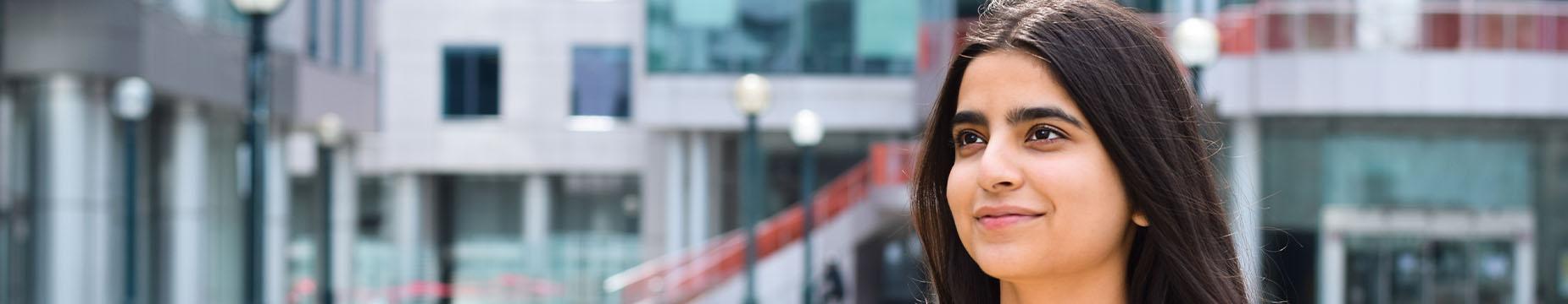 A woman is holding a tablet, engaged in reading or browsing content on the device.