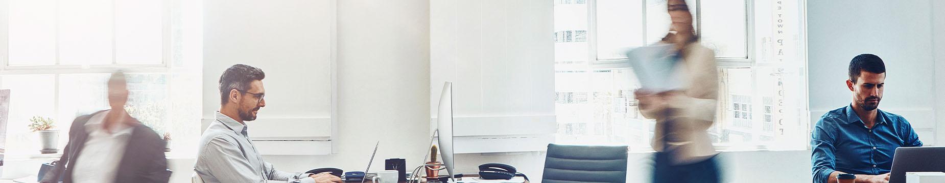 A diverse group of professionals engaged in discussion while seated around a conference table in an office setting.