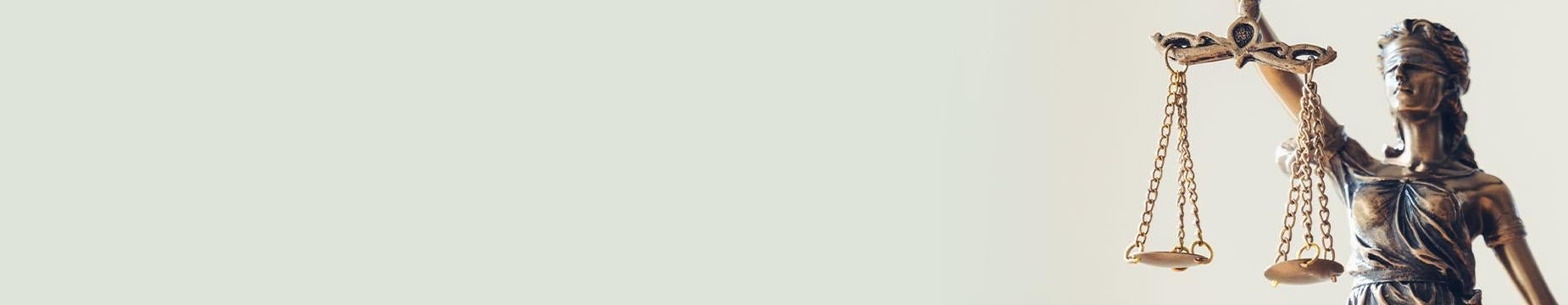 A statue of Lady Justice stands tall, holding a balanced scale, symbolising fairness and the rule of law.