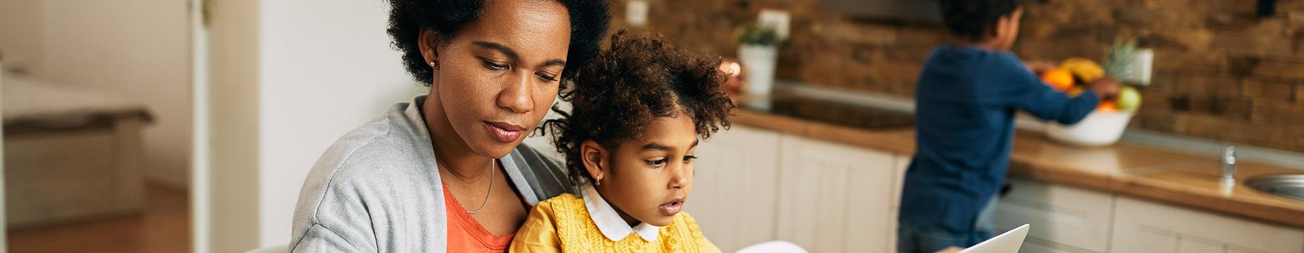 A woman and a child collaboratively working on a laptop, engaged in a productive learning experience together.