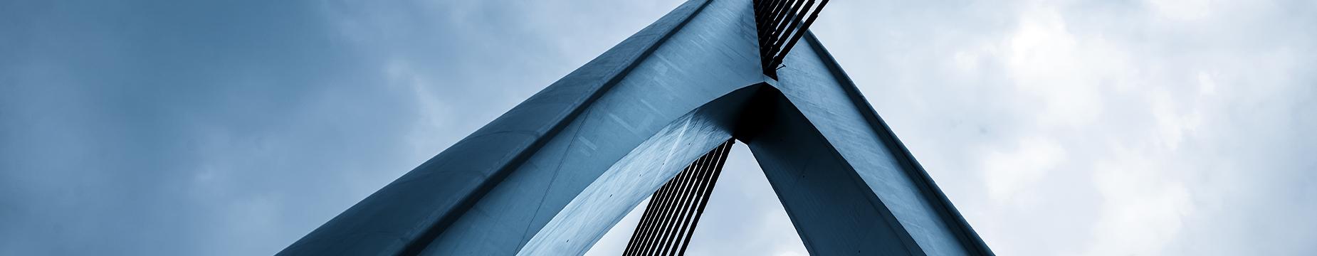 A close-up view of a bridge against a clear blue sky, showcasing its structure and the vibrant atmosphere.