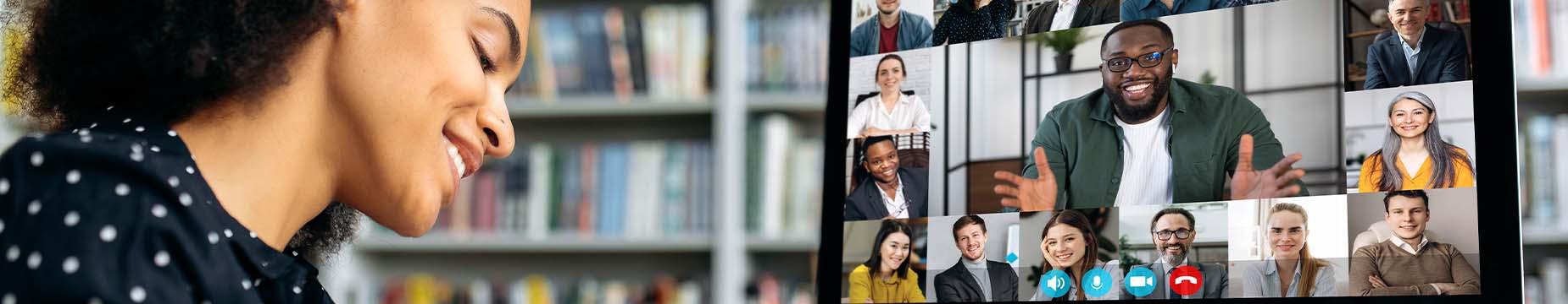 A woman seated at a desk, engaged in a video conference on her computer screen.