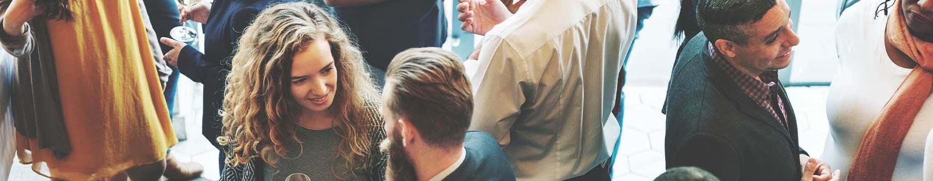 A diverse group of individuals standing in a line, showcasing unity and togetherness in a public setting.