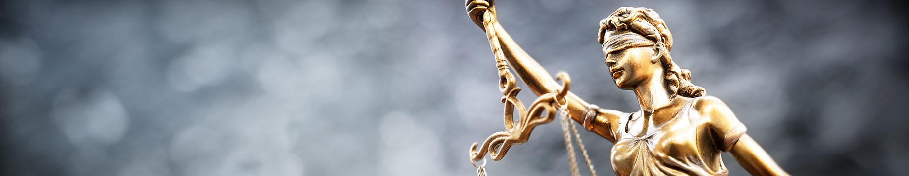 A statue of Lady Justice stands tall, holding a balanced scale, symbolising fairness and the rule of law.