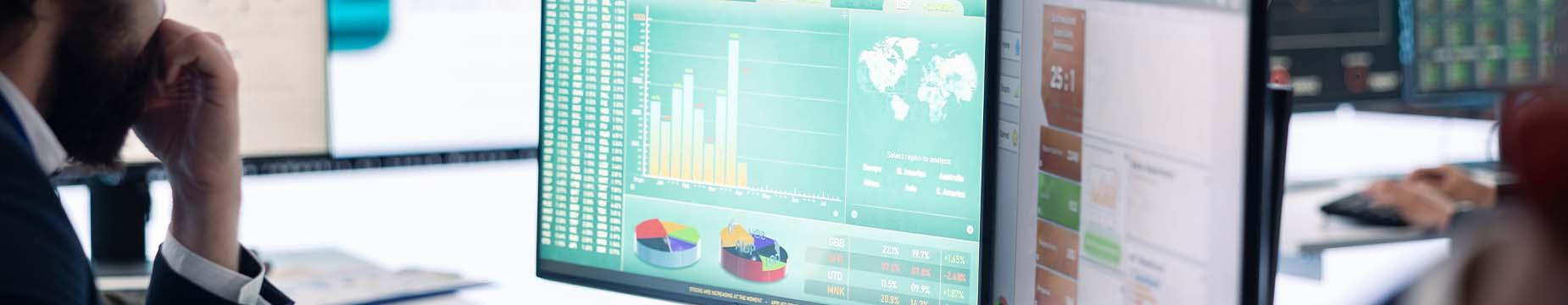 A person in a suit intently gazes at a computer screen, focused on their work or presentation.