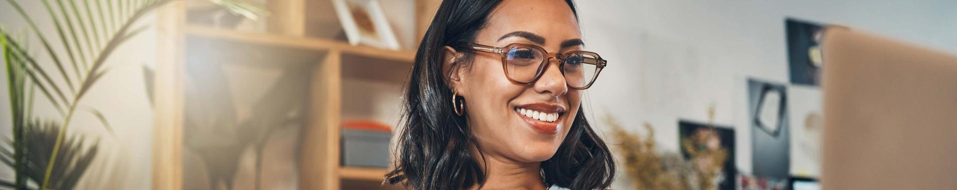 A woman wearing glasses, showcasing a thoughtful expression and a casual outfit.