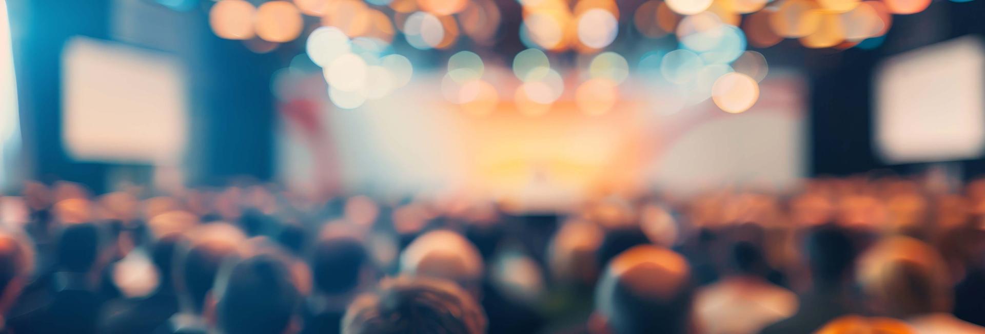 A diverse crowd of attendees engaged in discussions at a lively conference or event.