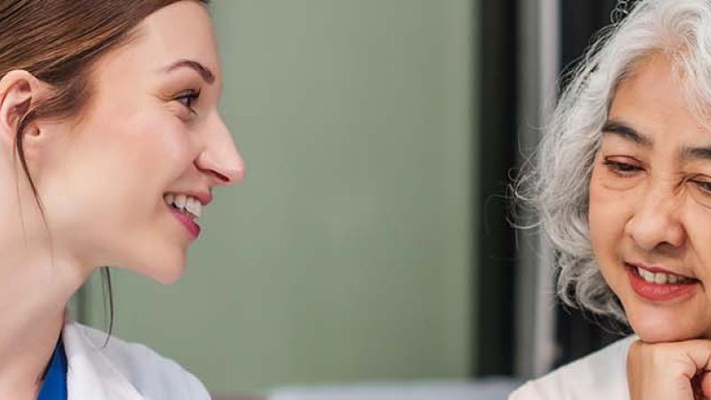 A doctor and patient engaged in a conversation at a desk, discussing health matters in a professional setting.