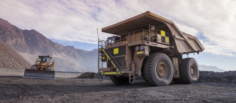 Two large machinery vehicles in an industrial site. 