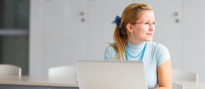 Female sitting at laptop wondering if she should get an MBA