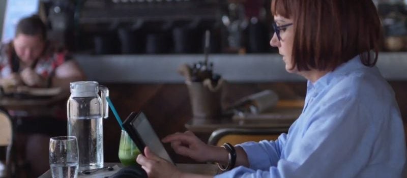 A woman studying on a tablet in a cafe.