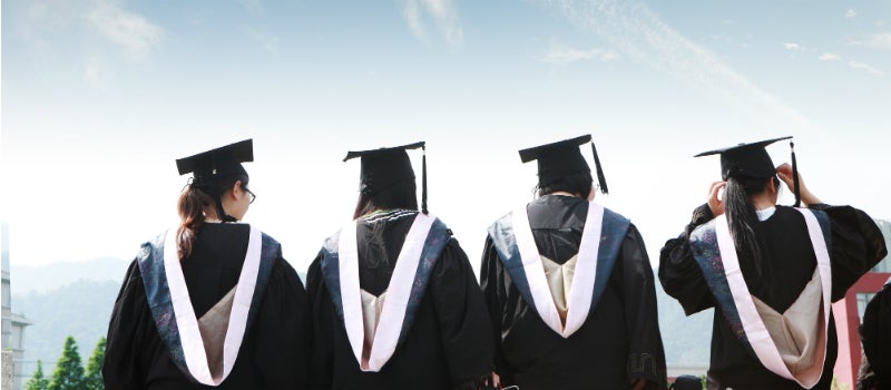 Students wearing graduation hats and gowns.