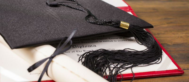 A square academic cap (graduation cap) on top of academic transcript.