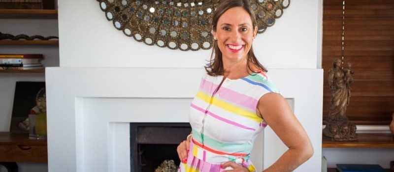 Bestselling author and 2018 SCU Vice Chancellor’s Alumnus of the Year, Bella Zanesco standing in front of fireplace. 